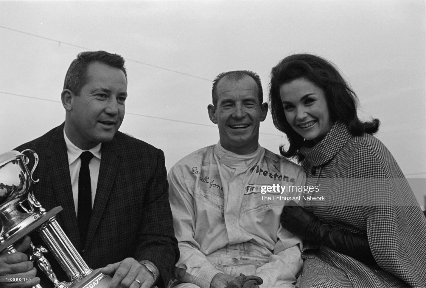 United States, January 30, 1967, Motor Trend 500, Riverside, NASCAR. Race winner Parnelli Jones receives his trophy from Robert E. Petersen (right) with actress and Race Queen Lara Lindsay. 