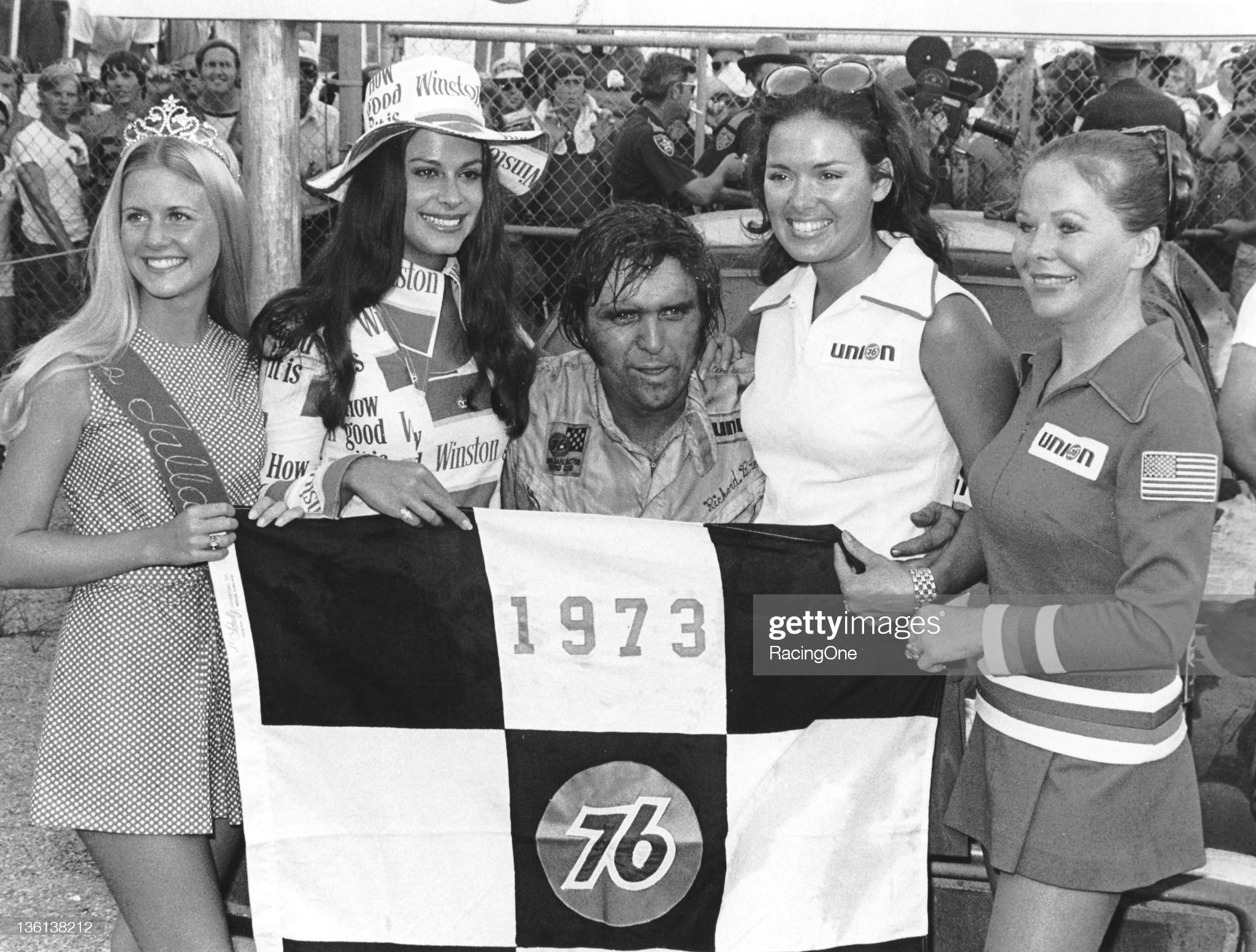 August 12, 1973: a tired Dick Brooks is joined by a bevy of race queens following the only NASCAR Cup victory of his career, the Talladega 500, at Alabama International Motor Speedway. 