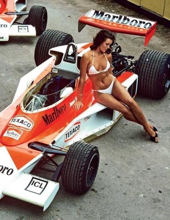 A vintage girl in a white bikini on a McLaren F1.