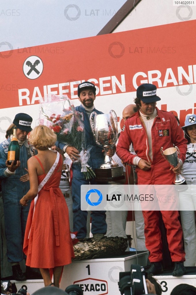 1976 Formula 1 World Championship: Osterreichring, Zeltweg, Austria. 13th - 15th August 1976. John Watson (Penske PC4-Ford), 1st position celebrates taking his maiden Grand Prix win and Penske's only victory with Jacques Laffite (Ligier JS5-Matra), 2nd position and Gunnar Nilsson (Lotus 77-Ford), 3rd position on the podium, portrait. 