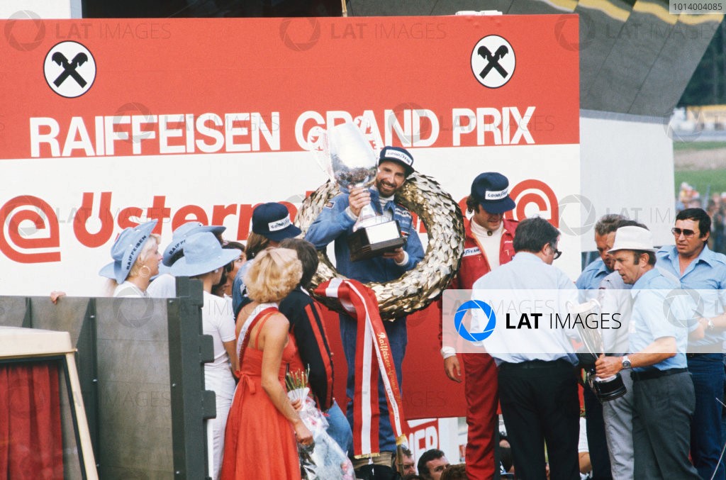 1976 Formula 1 World Championship: Osterreichring, Zeltweg, Austria. 13th - 15th August 1976. John Watson (Penske PC4-Ford), 1st position celebrates taking his maiden Grand Prix win and Penske's only victory with Jacques Laffite (Ligier JS5-Matra), 2nd position and Gunnar Nilsson (Lotus 77-Ford), 3rd position on the podium, portrait. 