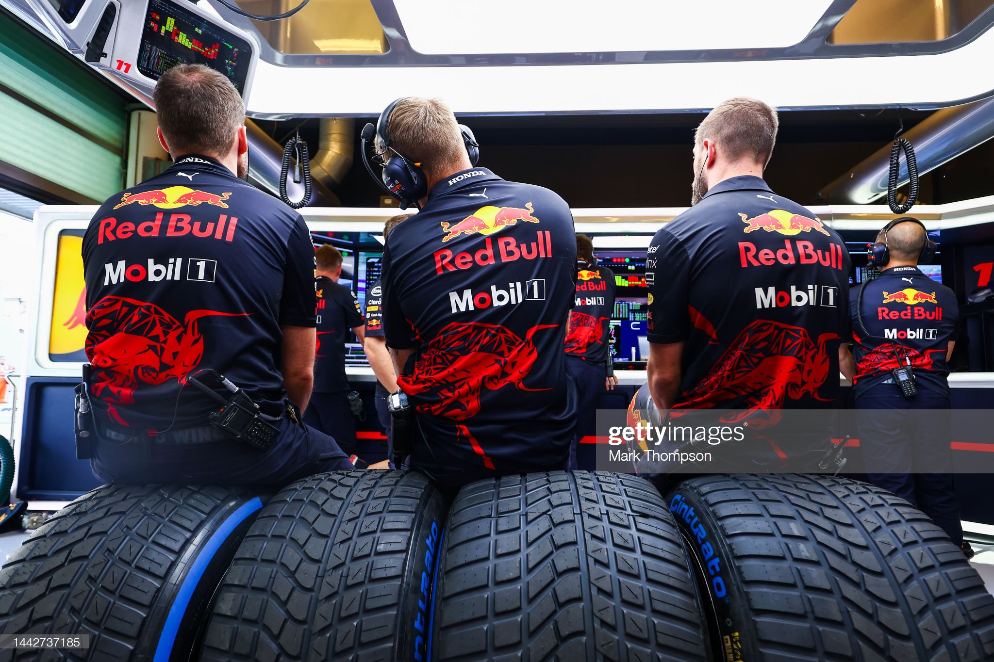 Red Bull Racing team members look on in the garage.