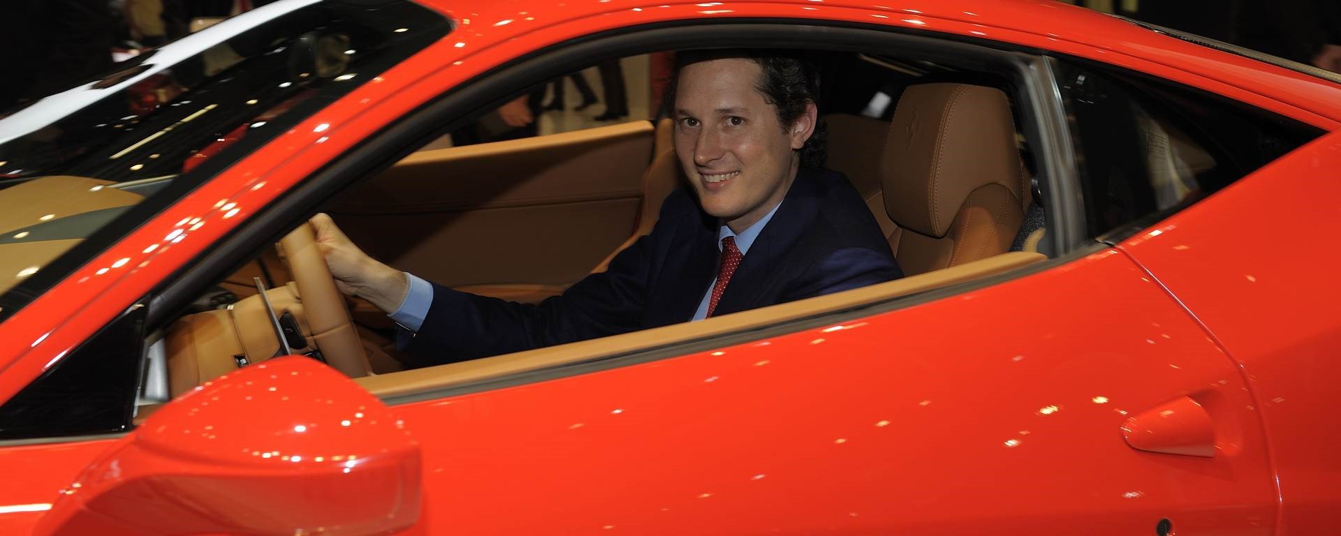 John Elkann in a red Ferrari.