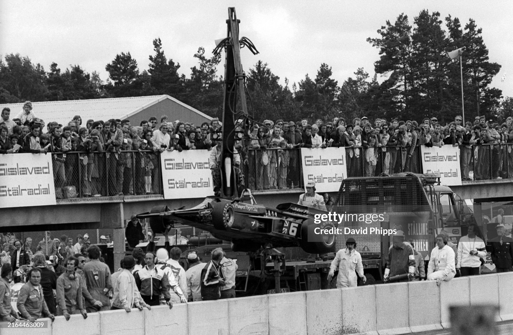The Lotus 77 of Gunnar Nilsson is removed from the circuit and onto a truck in the pit lane after he crashed out on lap 3 of his home Grand Prix at Anderstorp on 13 June 1976. 