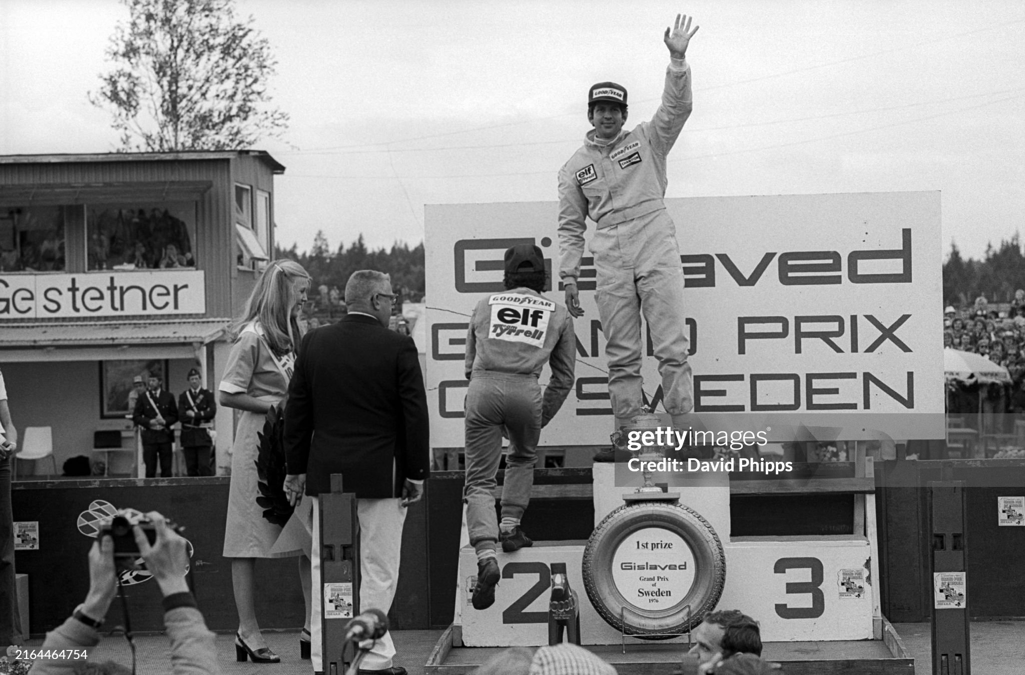 Race winner Jody Scheckter, Tyrrell, celebrates on the podium as his team mate Patrick Depailler takes his spot in second position at Anderstorp on 13 June 1976. 