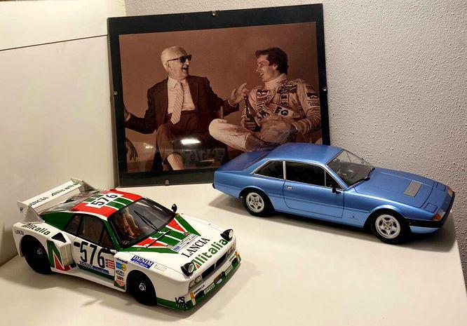 Two car models and a photo of Enzo Ferrari and Gilles Villeneuve.