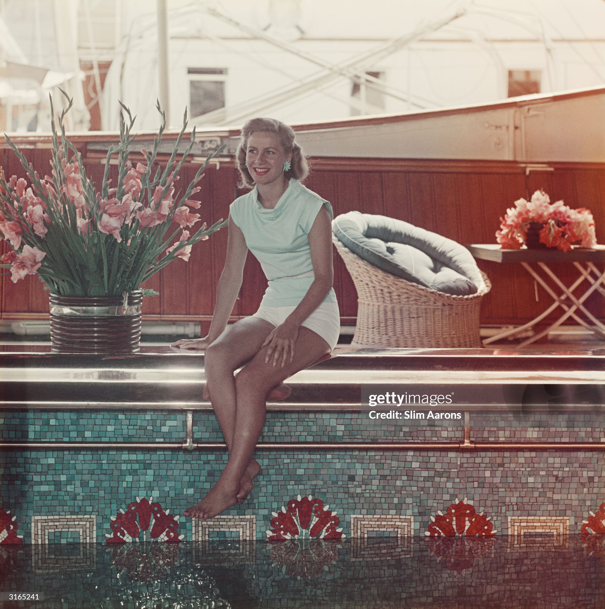 Athina Livanos Onassis (Tina), the first wife of Greek shipowner Aristotle Onassis, relaxing by the swimming pool aboard their yacht, the 'Christina', in Monte Carlo in 1958. 