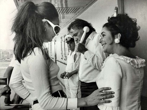Richard Burton, taking a phone call and Elizabeth Taylor (right). 