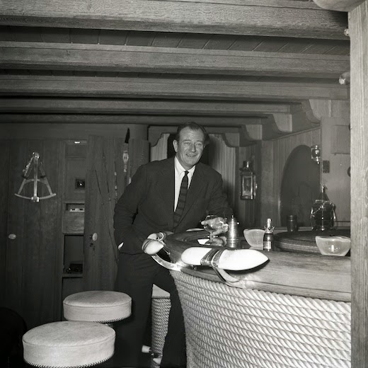 John Wayne ordering a drink at the iconic Ari's Bar — named after its owner — aboard the Christina. 