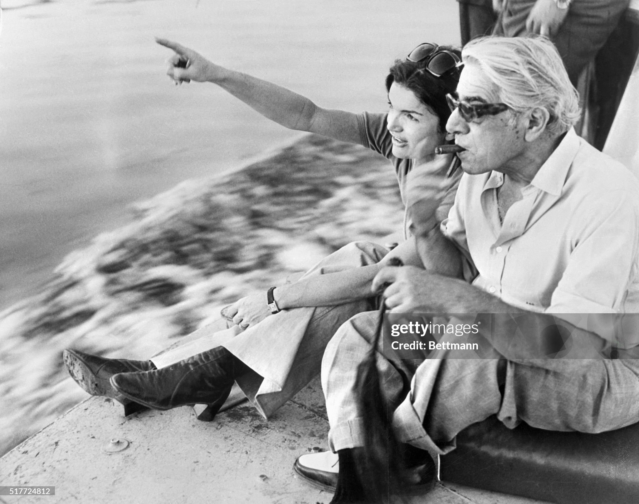 Jacqueline Kennedy Onassis and a cigar-smoking Aristotle Onassis relax along a river during their 10-day tour of Egypt on 28 March 1974.