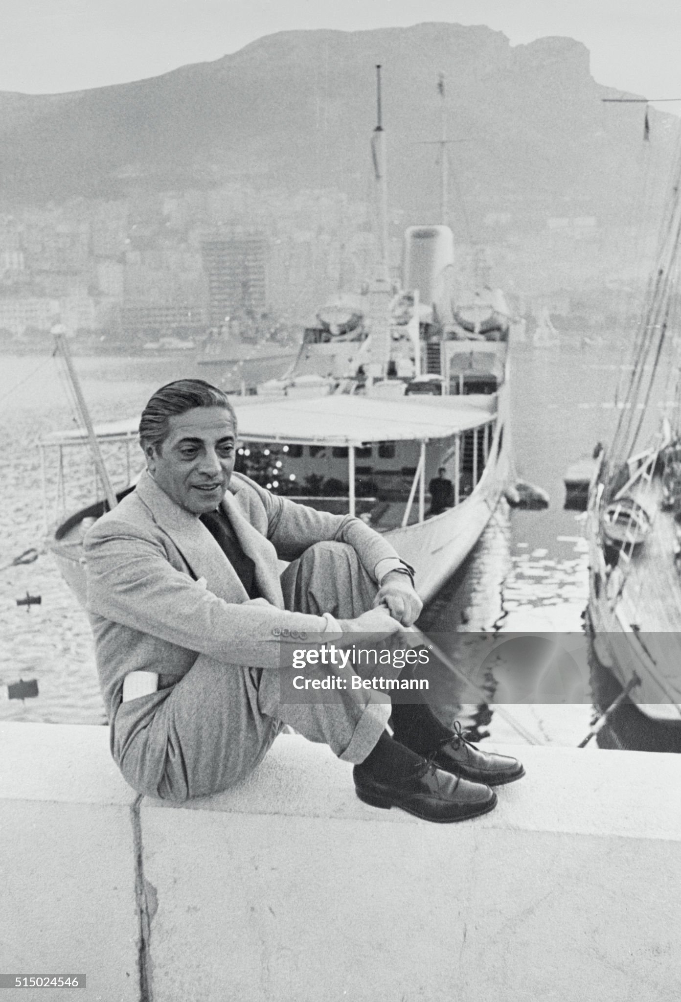 Sitting on the quay wall in front of his converted $2,5000,000 destroyer yacht ‘Christina’ is Greek shipping magnate Aristotle Onassis on 16 April 1956. 