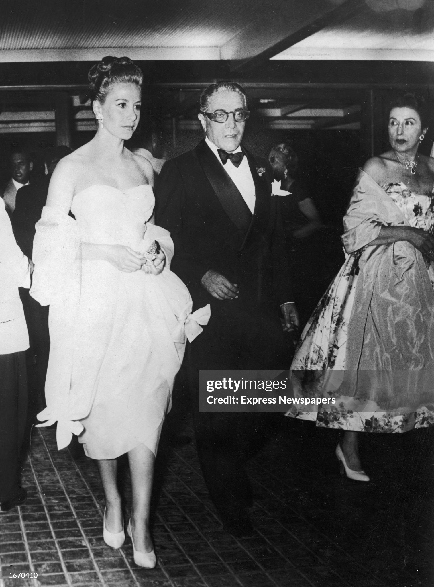 Aristotle Onassis and his first wife Athina arrive at a party, as Greek actor Katina Paxinou (right) (1900 - 1973) looks on, near Athens, Greece, in July 1957. 