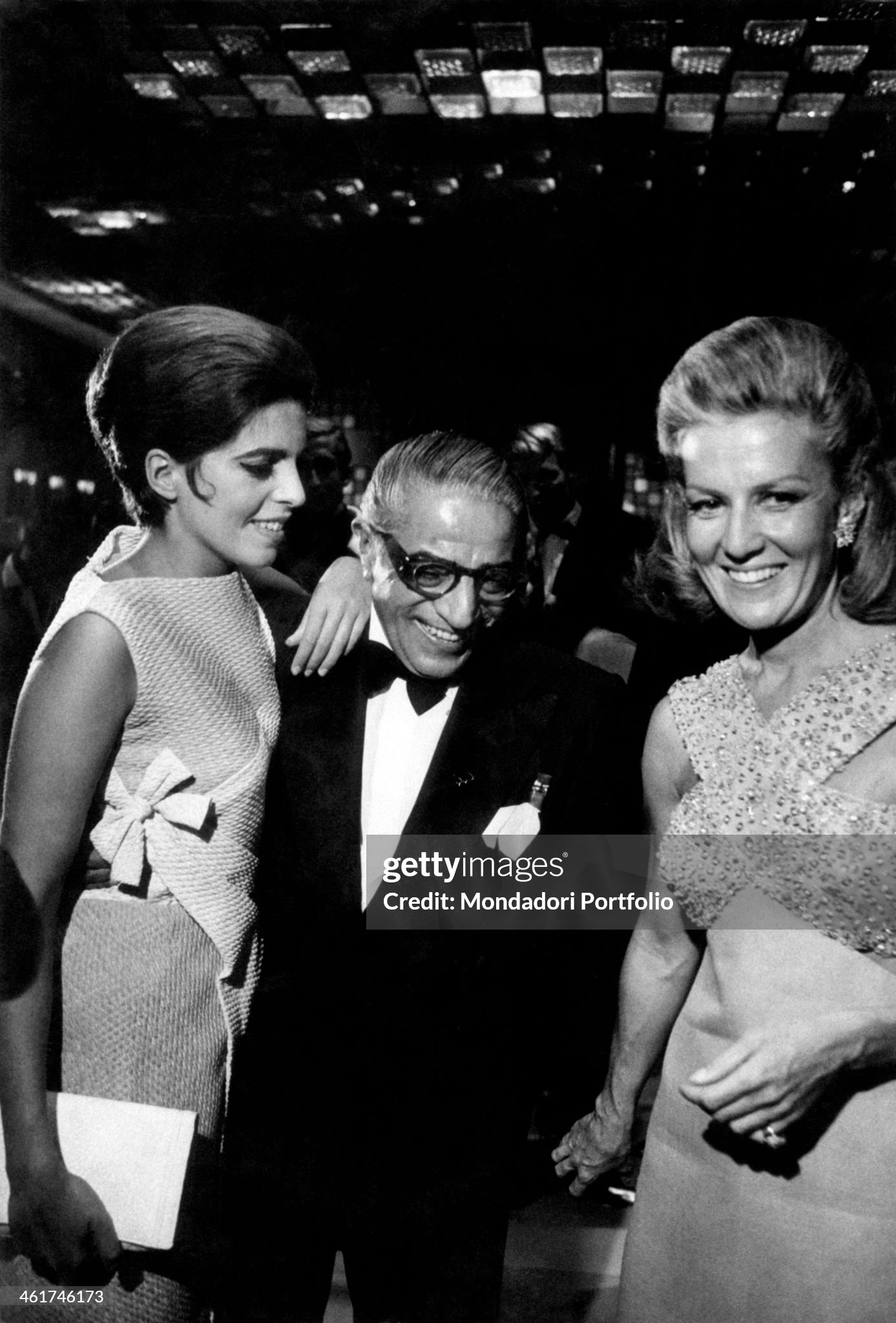 Aristotle Onassis smiling in dinner jacket beside his Greek daughter Christina Onassis and Italian countess and film producer Marina Cicogna. They're attending a party at Ca' Rezzonico in Venice in September 1967. 
