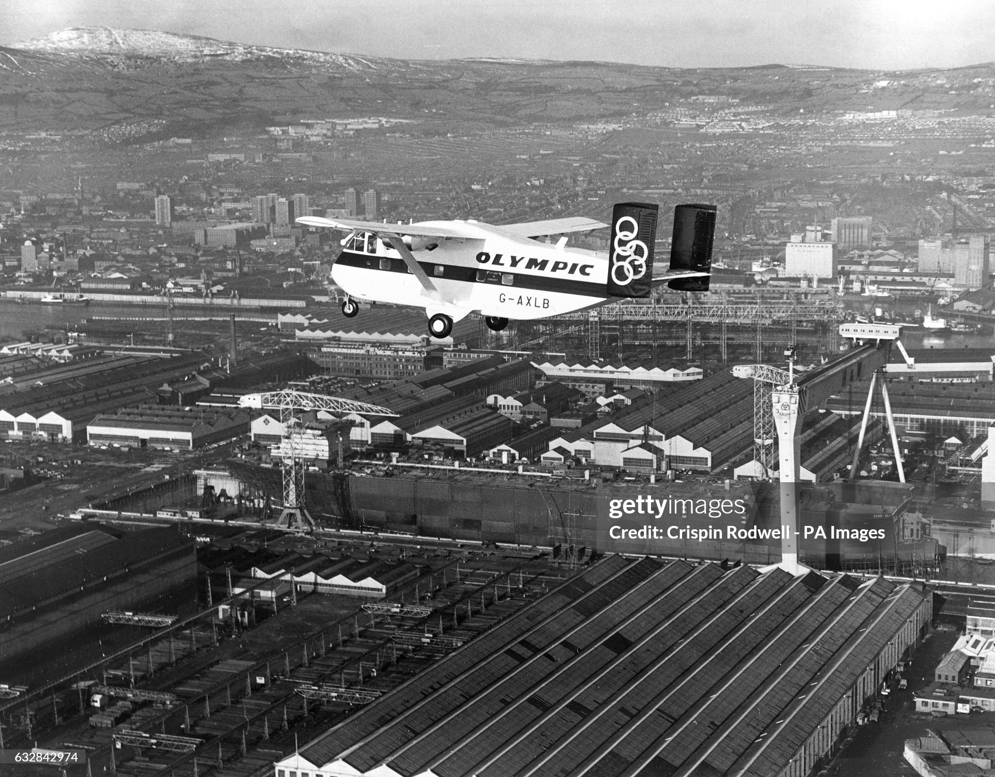 The first of two Short Skyvan light transports for the Greek national airline Olympic Airways flies over the new £7million building dock and £1.25million gantry crane at Harland and Wolff's shipyard in Belfast on 23 March 1970. 