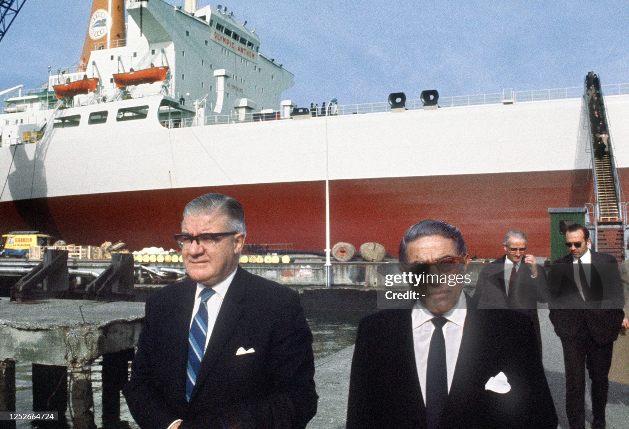 Aristotle Onassis talks with an unidentified French official on 30 October 1970 in Saint Nazaire dockyards prior to the launching of his new 220,000 ton-tanker Olympic Anthem (background). 
