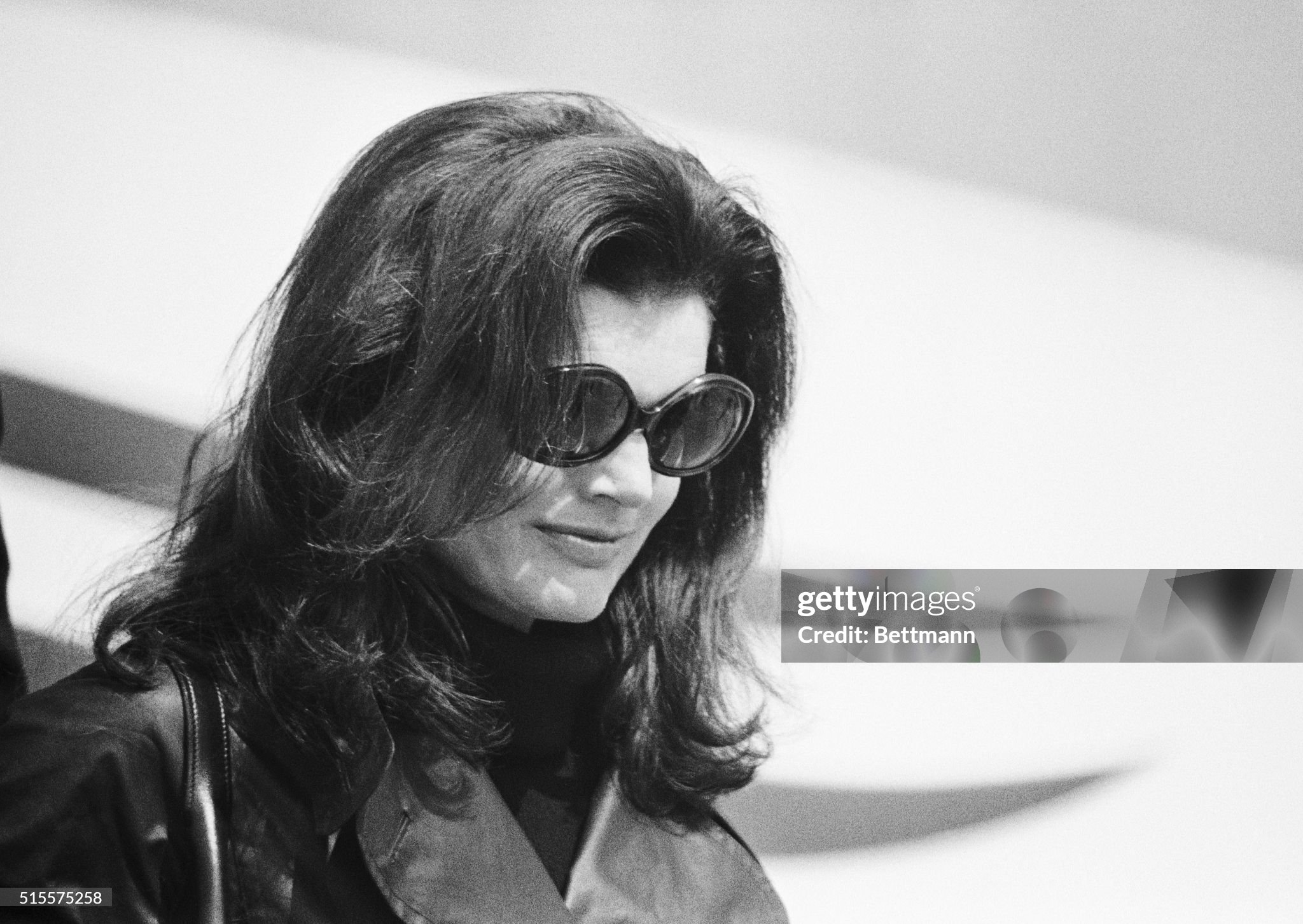 Jacqueline Kennedy Onassis, wearing dark glasses and black leather coat over a black outfit, leaves her chartered Olympic Airlines plane after accompanying the body of her late husband, Aristotle Onassis, on a flight from Paris. 