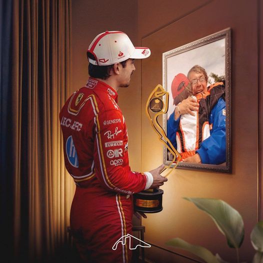 Charles Leclerc, with the trophy of his victory at Monza with Ferrari in 2024, in front of a painting depicting an embrace between him and his father Hervé.