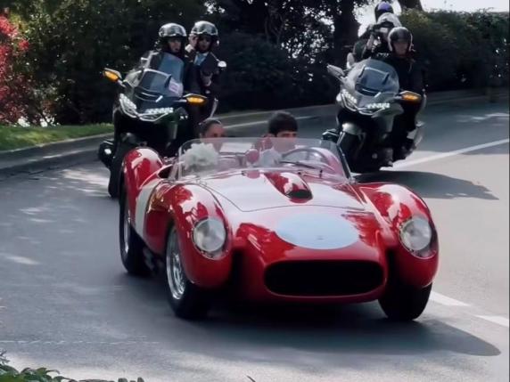 Charles and Alexandra riding together in a striking vintage red Ferrari 250 Testa Rossa.