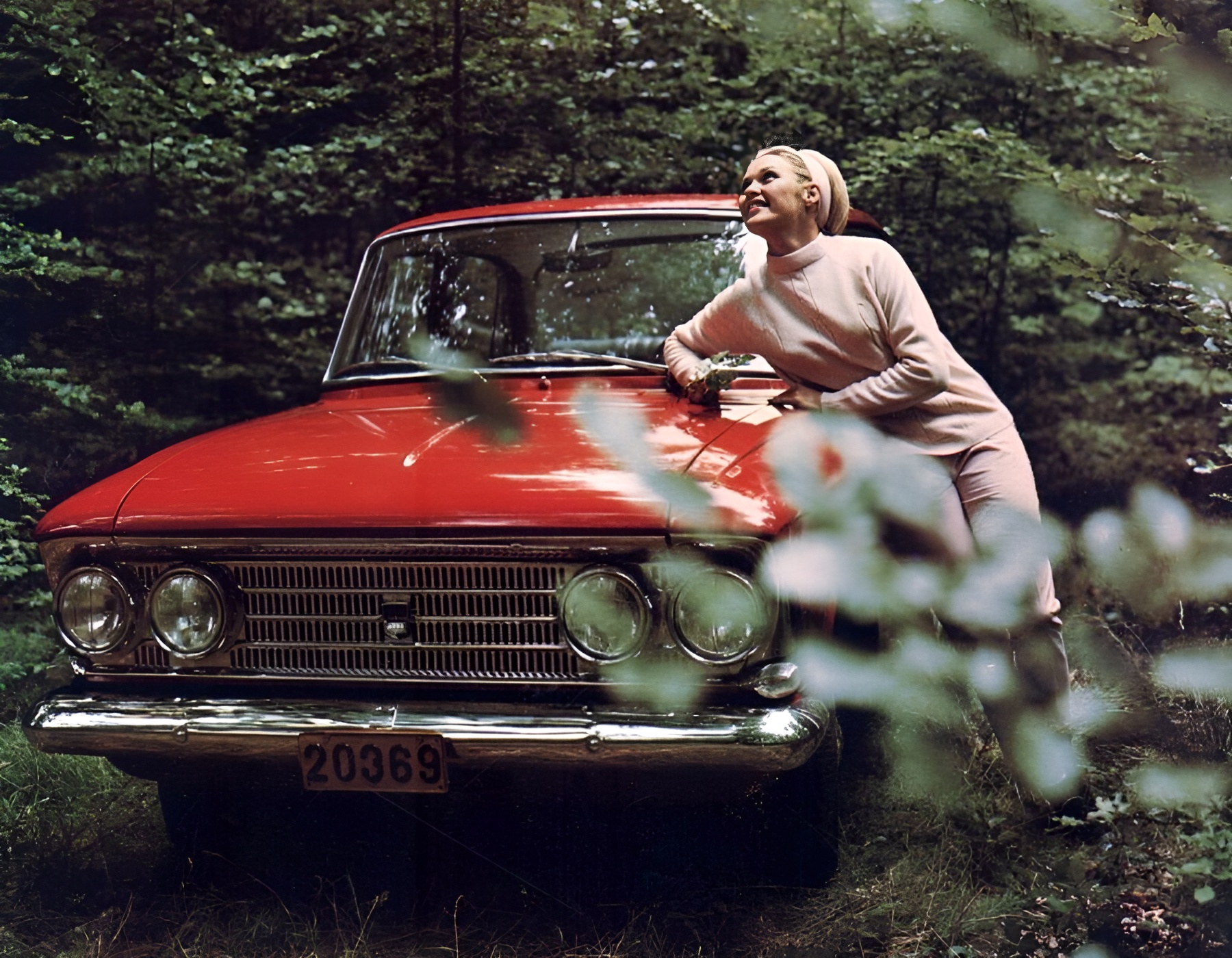 A blonde Russian girl and a red Moskvitch 408.