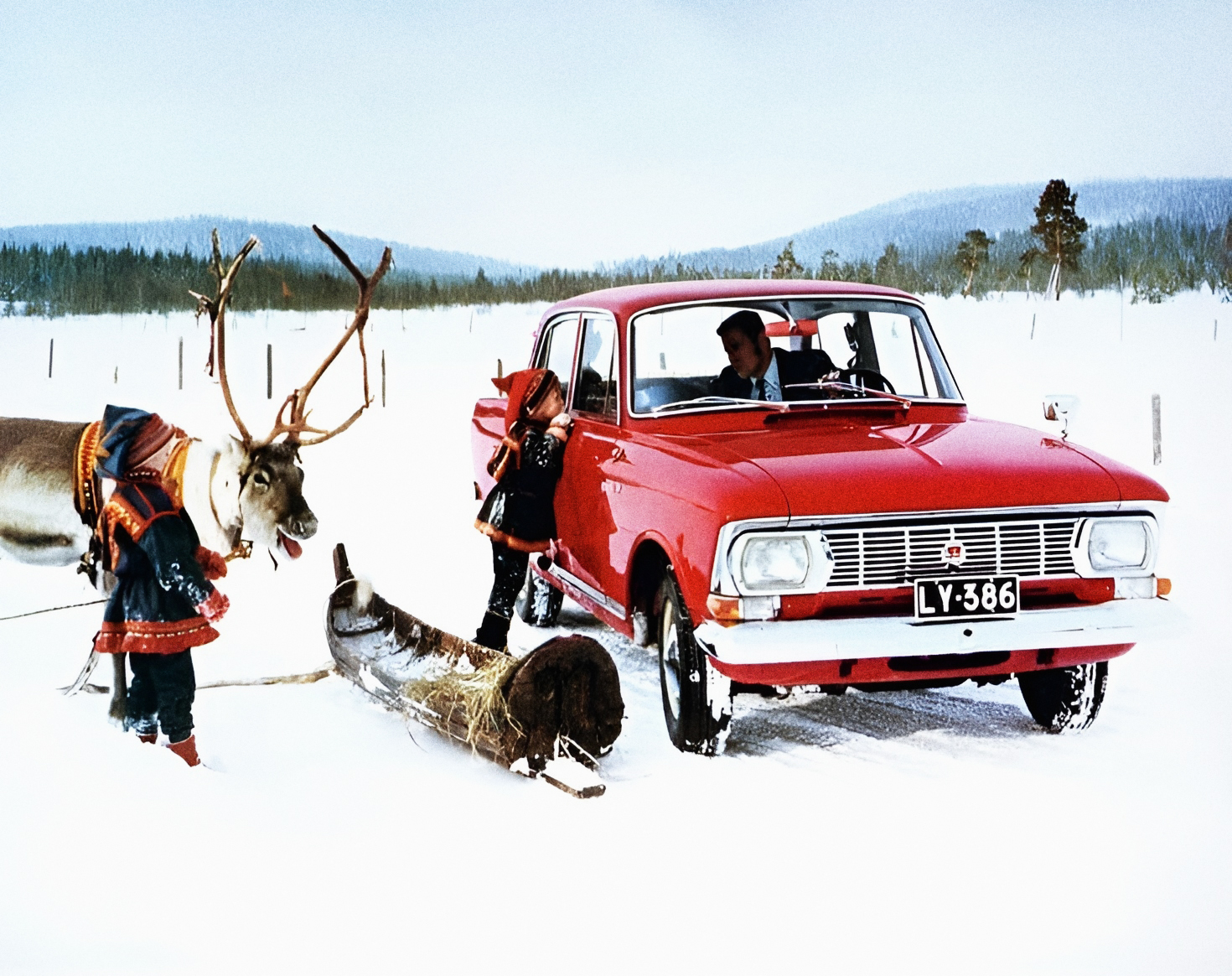 A red Moskvitch, a man, two children and... a reindeer.