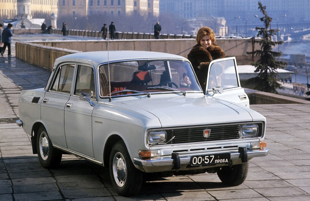 A lady and a white Moskvitch 2140.