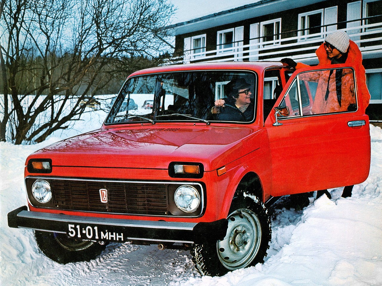 A man. a woman and a red Lada Niva.