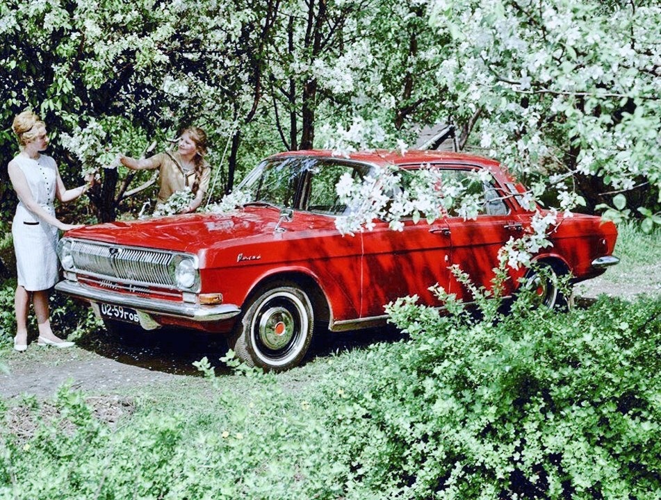 Two girls and a red Volga GAZ M-24.