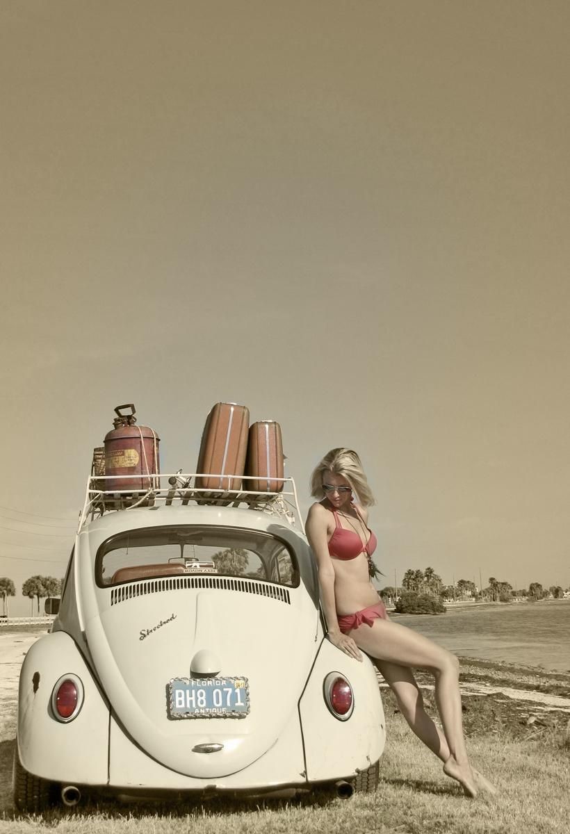 A woman in a bikini and a Beetle.
