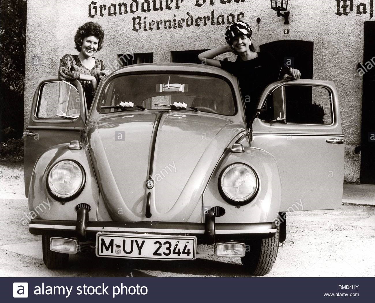 2 women standing near a Beetle built in 1960.