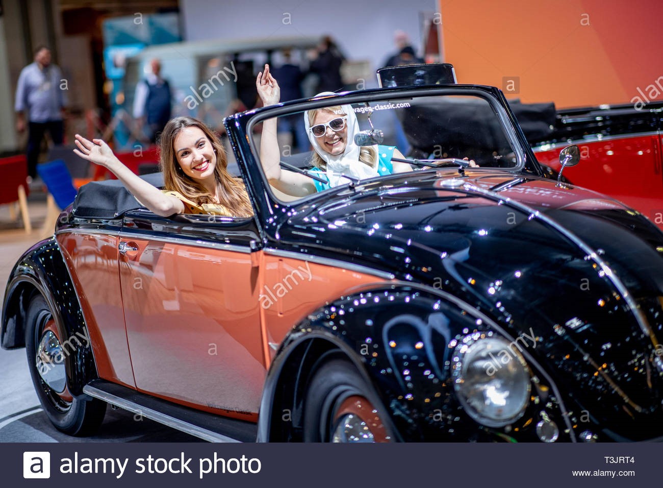 Essen, Germany. 10th April, 2019. The models Vivien (left) and Alida sit at the Techno Classica for-classic cars and youngtimers in a VW Beetle cabriolet from 1950. The world fair takes place from 10th to 14th April. 