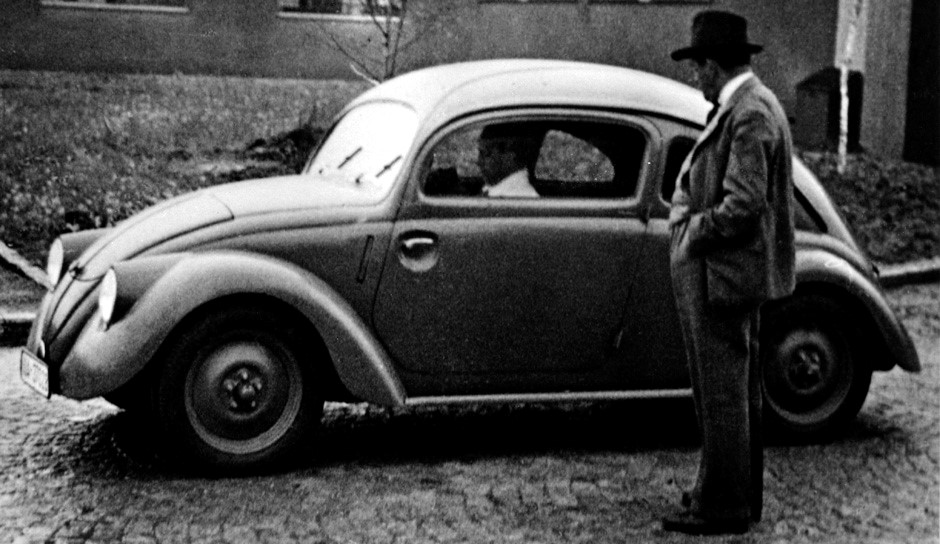 1937. Ferdinand Porsche seen with a car from the W30 series of Volkswagen prototypes. 