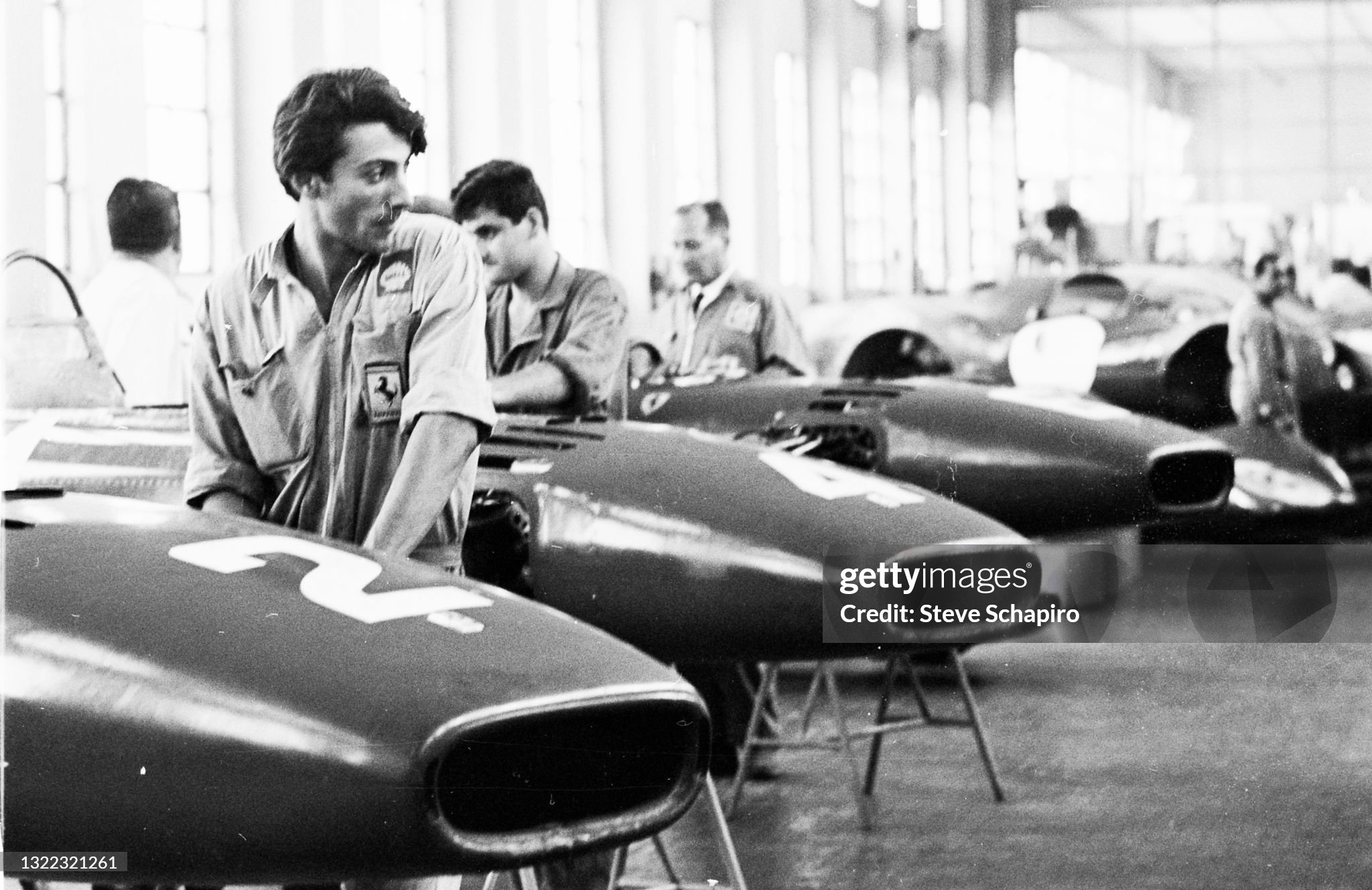 View of a line of employees and cars in the Ferrari automobile factory at Maranello, Italy, in 1966. 