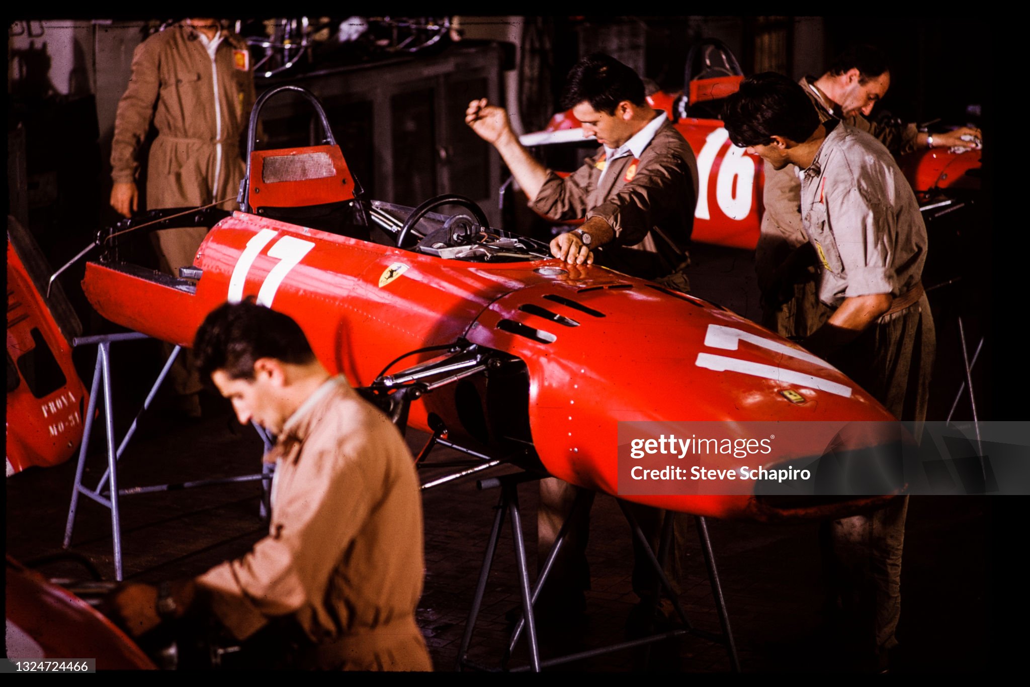View of a line of employees and cars in the Ferrari automobile factory at Maranello, Italy, in 1966. 