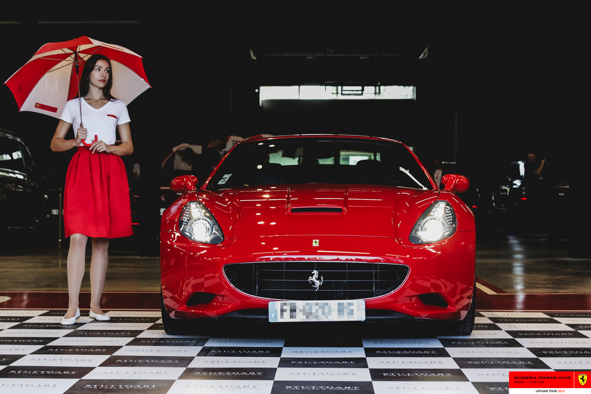 A grid girl and a red Ferrari ready to start the tour.