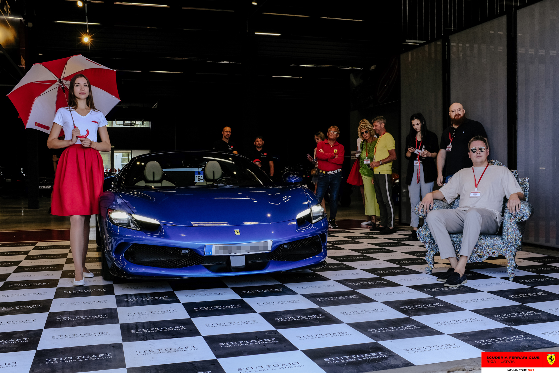 A grid girl and a blue Ferrari ready to start the tour. 