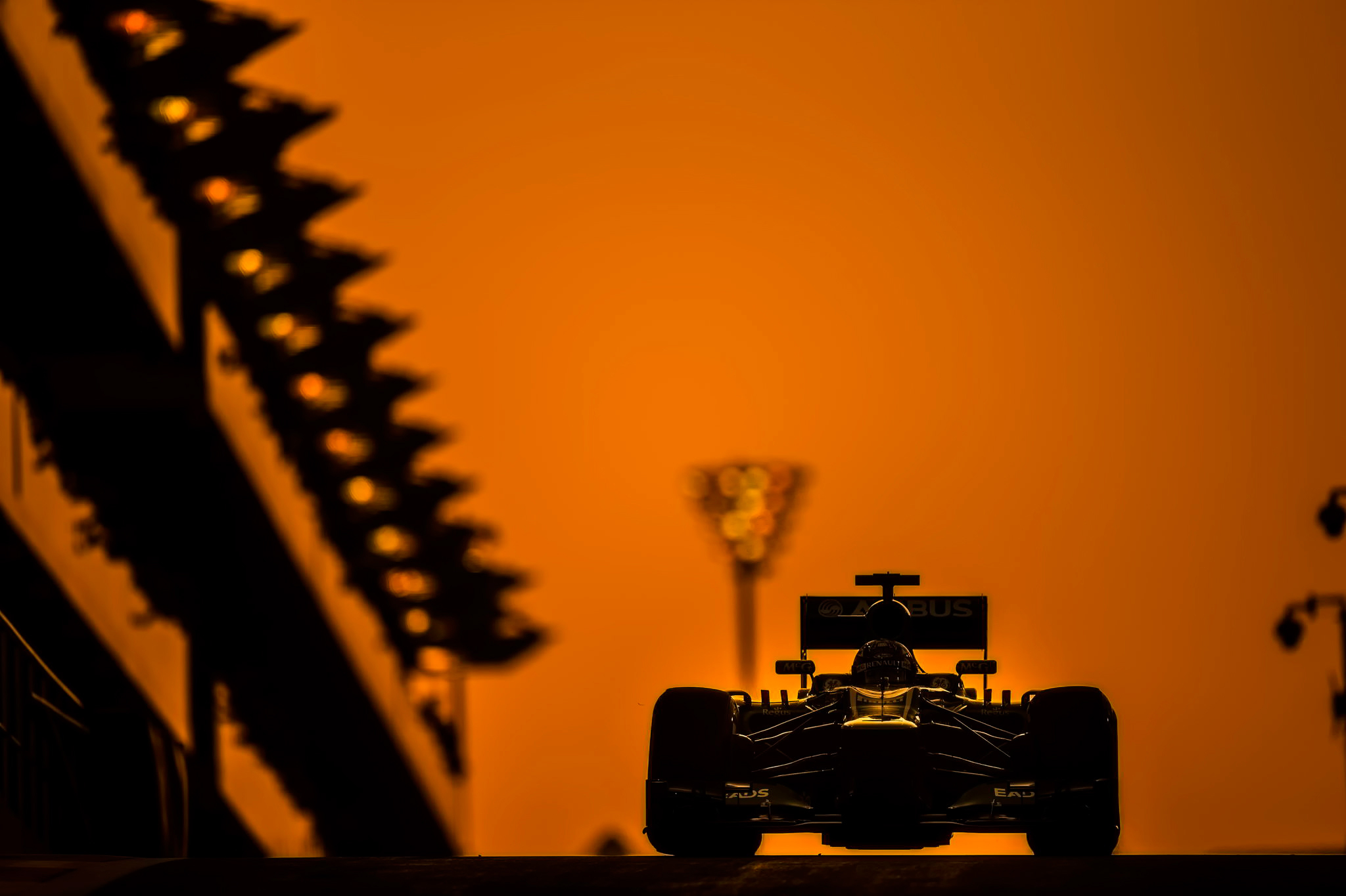 A Formula 1 race car in the light of an orange sunset.