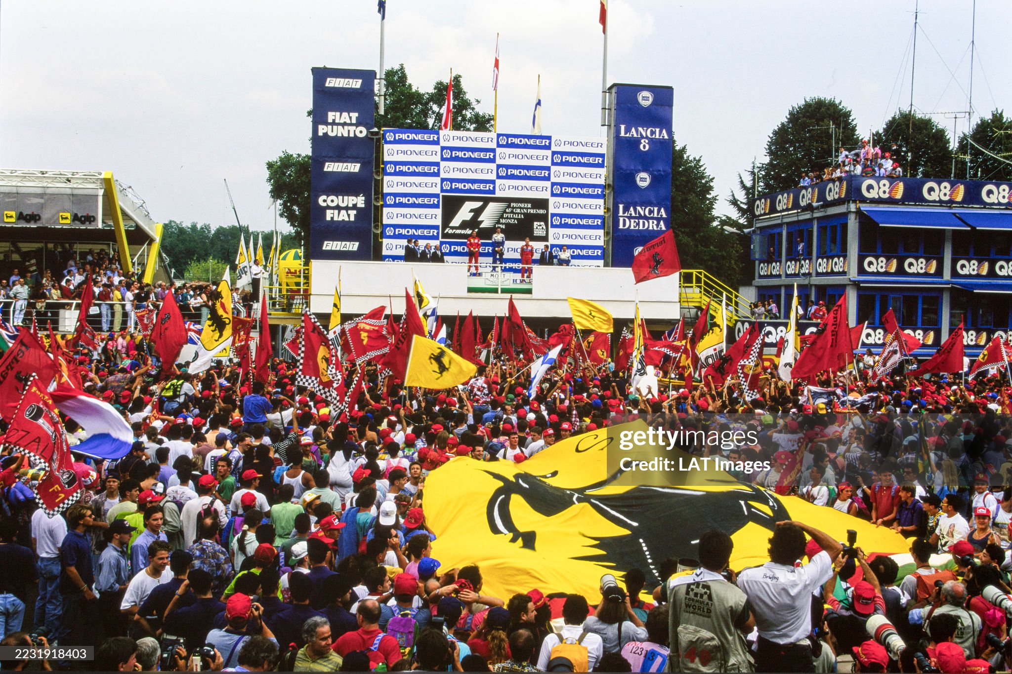 Damon Hill, 1st position, Gerhard Berger, 2nd position and Mika Häkkinen, 3rd position, on the podium as the crowd unfurls an enormous Ferrari logo at the Italian Grand Prix at Autodromo Nazionale Monza on 11 September 1994. 