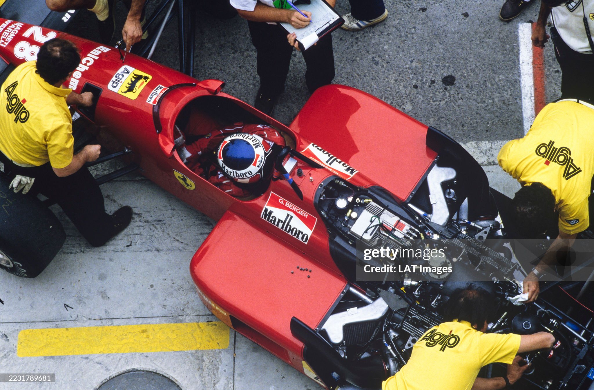 Gerhard Berger, Ferrari F1-87, has his car worked on by mechanics in the pits during the Portuguese Grand Prix at Circuito Estoril on September 20, 1987. 