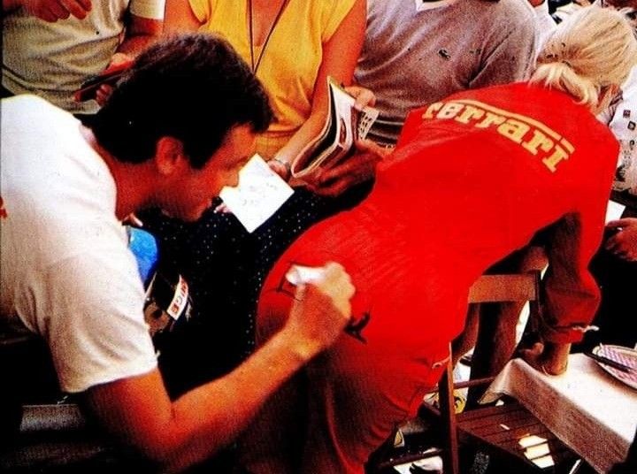 Patrick Tambay signs an autograph on the bottom of a Ferrari female fan.