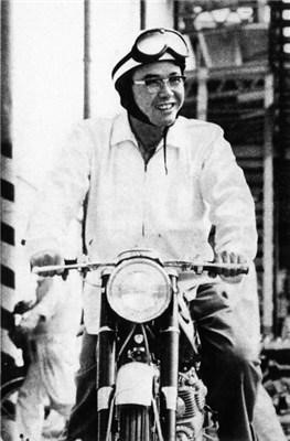 Soichiro Honda riding a bike.