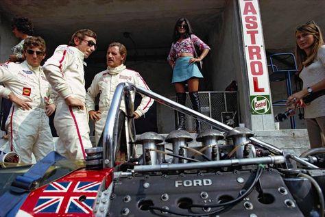 Jochen Rindt with Graham Hill and another driver in front of a girl.