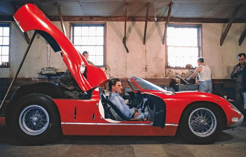 Graham Hill sat in his on working #2 Maranello Concessionaires Ferrari 330P here at the pit garage of Circuit de La Sarthe, Le Mans, in 1964. 