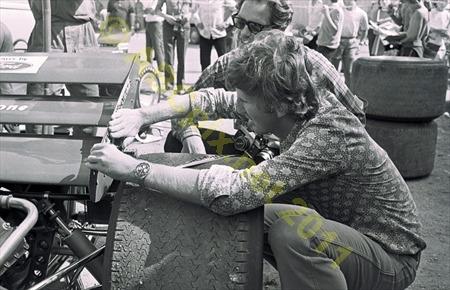 Jochen Rindt sticks some stickers on his car. 