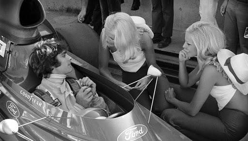 Francois Cevert in a Tyrrell talking with two girls. 