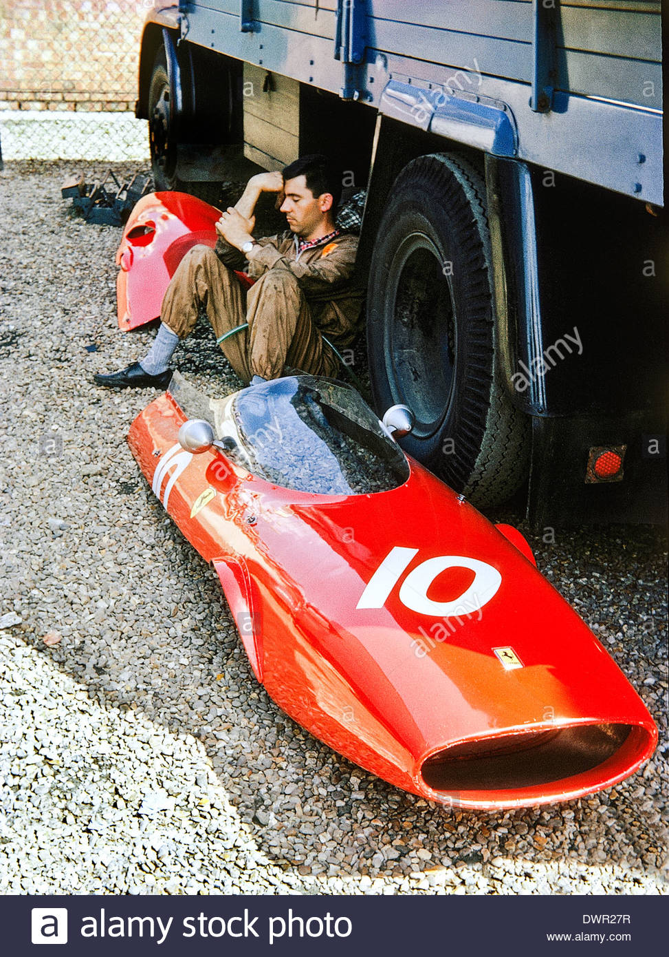 A mechanic with bodywork from John Surtees Ferrari 157 at Silverstone.