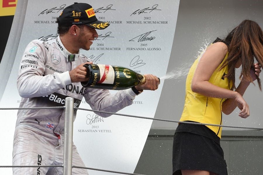 Lewis Hamilton celebrates his victory by soaking a grid girl with champagne at the Spanish Grand Prix on 11 may 2014.