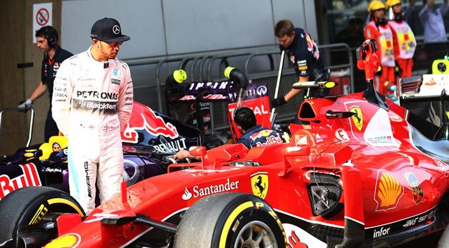 Lewis Hamilton looks at the Ferrari of Sebastian Vettel in parc ferme after qualifying for the Formula One Grand Prix of Russia at Sochi Autodrom on October 10, 2015.