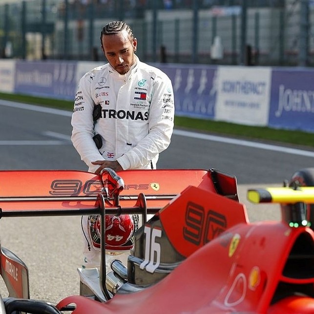 Lewis Hamilton looking at a Ferrari F1.