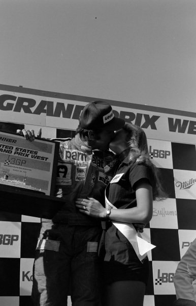 Clay Regazzoni, 1st position, gets a kiss on the podium at the USA West Grand Prix in Long Beach on 28 March 1976. 