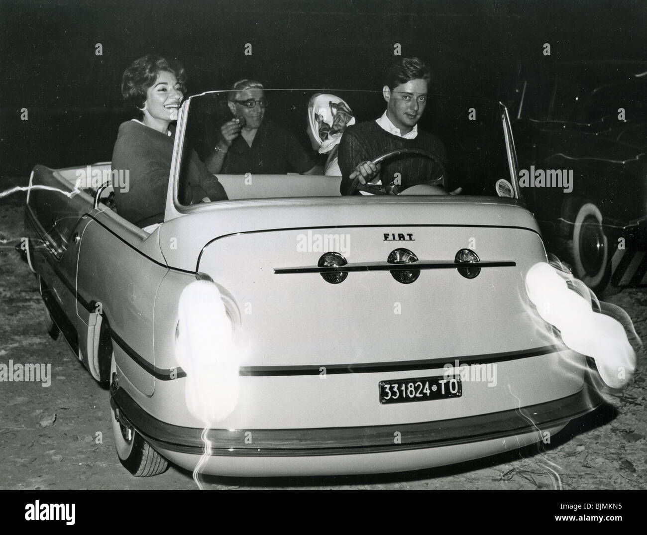 Maria Callas with Aristotle Onassis in back seat of their FIAT car.